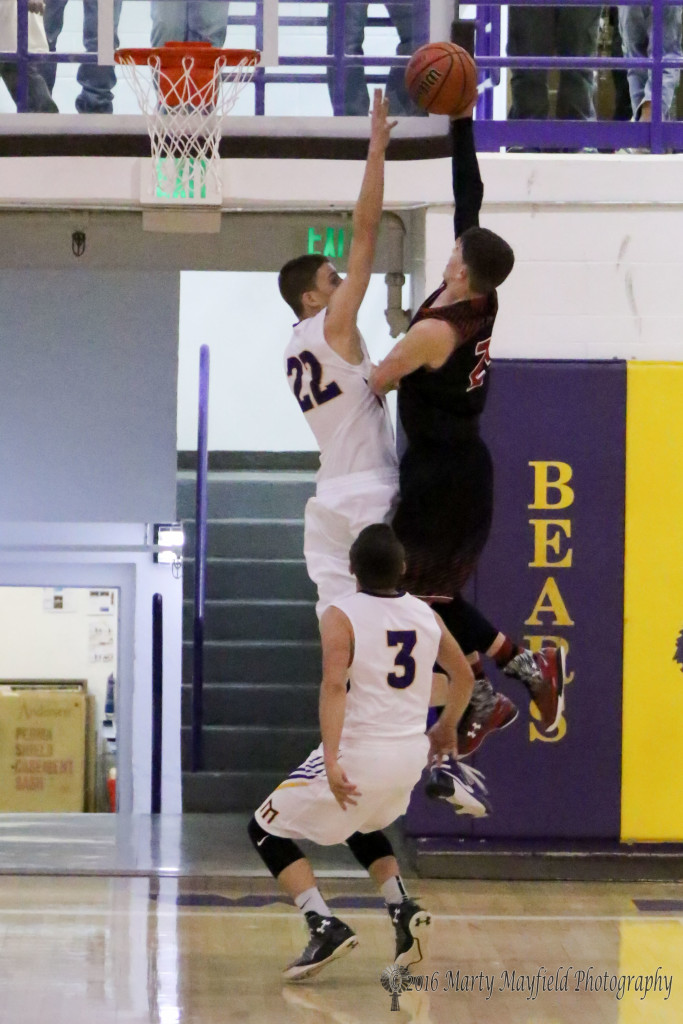 Kolten Riggs (22) goes for the block on Isaiah Garcia (24) as he drives in for the lay-up Friday night in Maxwell