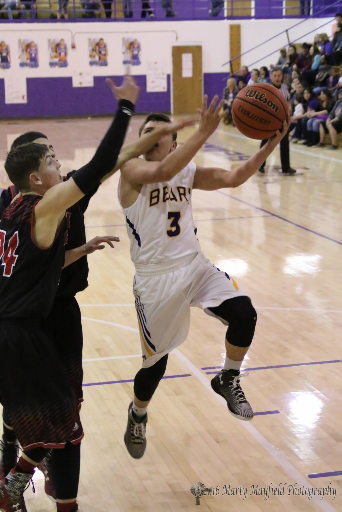 Bryan Romero gets a hand on Jeremy Archuleta (3) as he drives into the lane Isaiah Garcia is there to help out as well