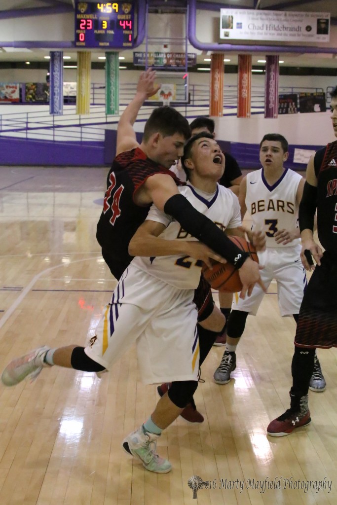 Andrew Archuleta (24) drives the lane as Isaiah Garcia (24) comes down on him after making a leap for the block. 