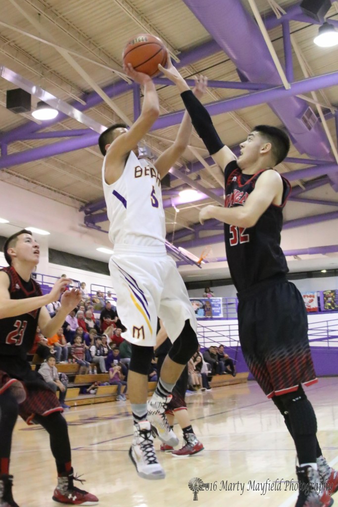 Zac Caldwell (32) goes for the block and gets a hand on the ball as Carl Gonzales (5) goes up for the shot.