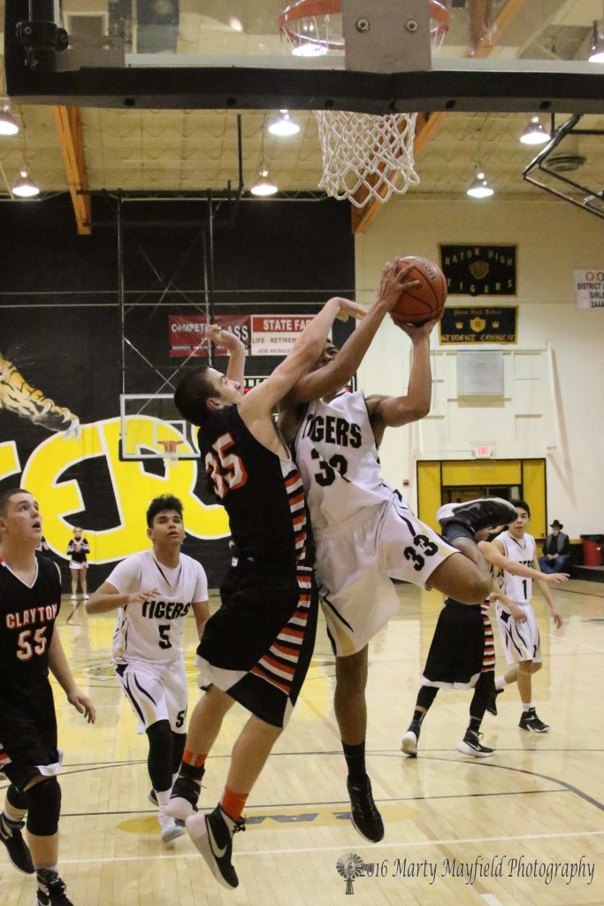 Darien Lewis drives the lane as Kobie Montoya reaches in for the block 