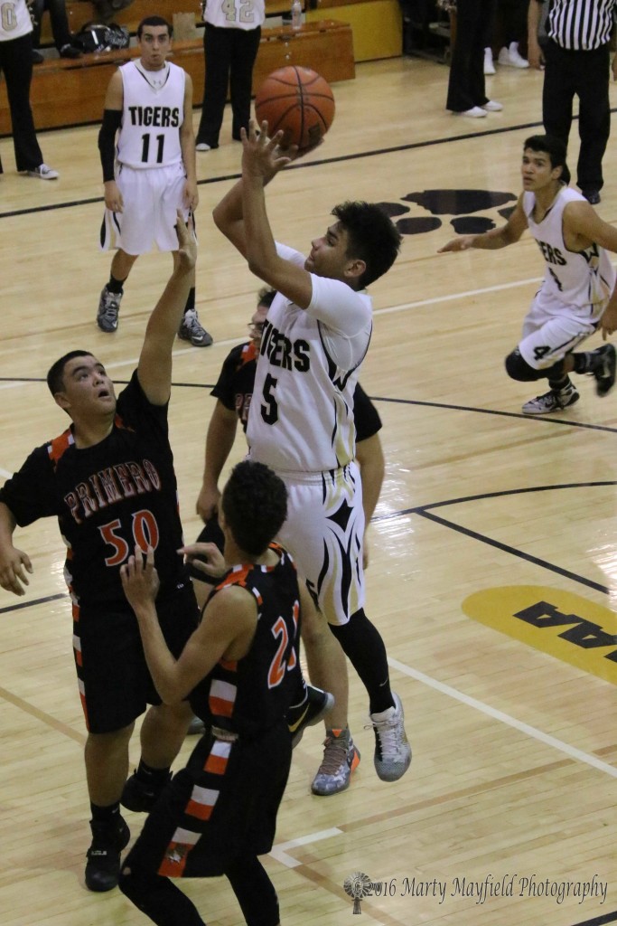 Austin Jones goes for the short jumper as Joey Archuleta (50) and Vince Damelio (21) attempt the block