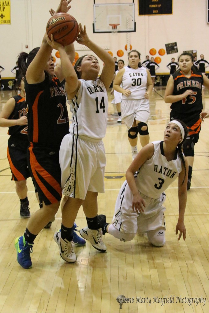 Taylor Mestas (22) squeezes in behind Andie Ortega (14) and gets a hand on the ball as Andie goes for the shot 