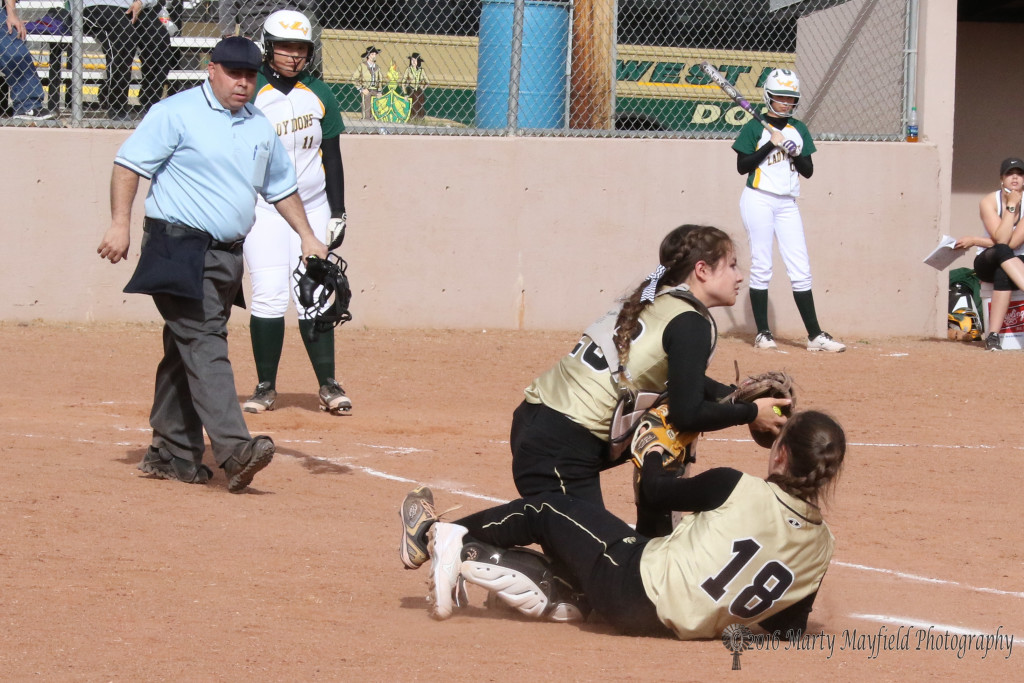 Camryn Stroeker keeps control of the foul ball as her and first baseman Halle Medina tangle up 