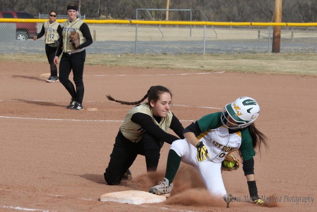 Halle Medina goes for the tag as the West Las Vegas player slides back to first during game 2 of the double header.