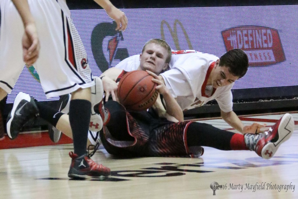 Jacob Eggleston and Jacob Quintana wrangle for the ball as they go to the floor to gain control of the ball.