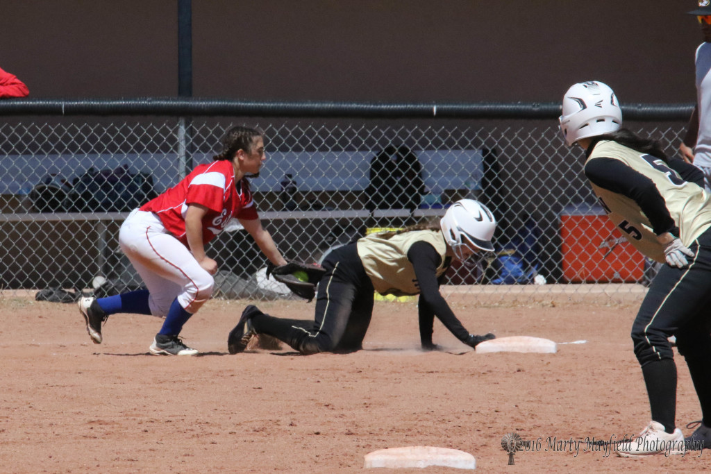 Halle Medina tags up as third baseman Laney Chavez reaches for the tag 