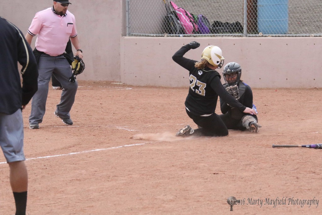 safe at home plate as Jadyn Walton slides home. The ball flew past catcher Seanall Leon in game two of the double header.