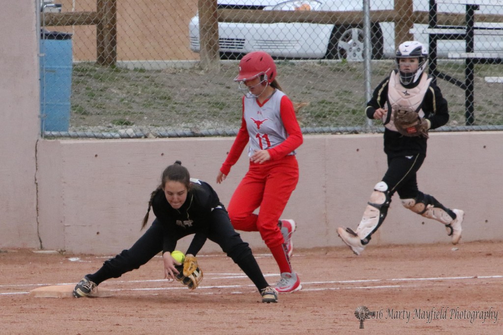 Out at first as Halle Medina takes control of the ball before as Paige Moralez closes in on first base.