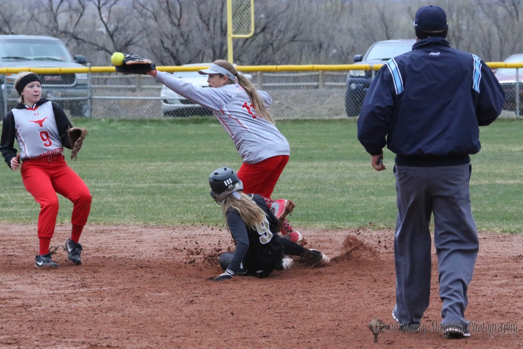 Another play at second as Mariah Encinias slides into second causing Paige Moralez to miss the throw from home plate. 