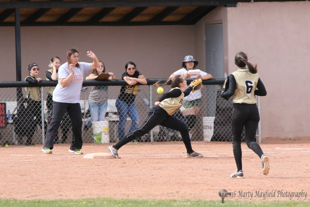 The ball flies wide as Halle Medina reaches out for the throw from third. 