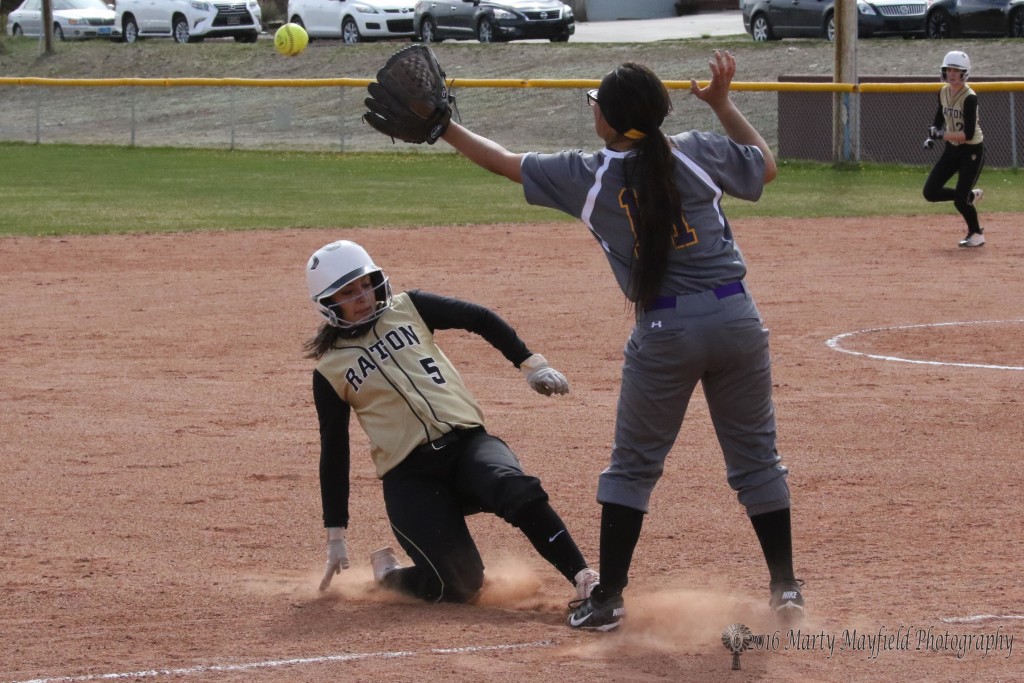 Sophia Madellini slides into third under the ball as it arrives late to third baseman Audriana Lalane. 