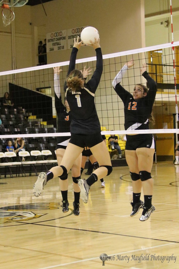 Mya Jimenez(12)  goes up for the block as Camryn Mileta (1) sends the ball over the net during the RHS tourney Thursday evening in Tiger Gym