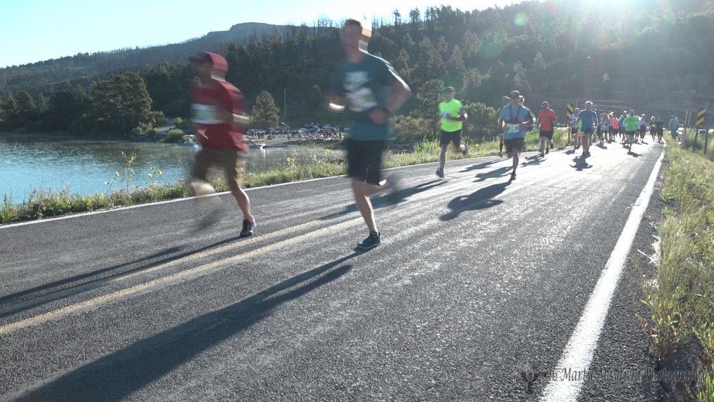 Runners cross the Lake Maloya Dam as the 2016 MOM adventure race gets under way Saturday morning