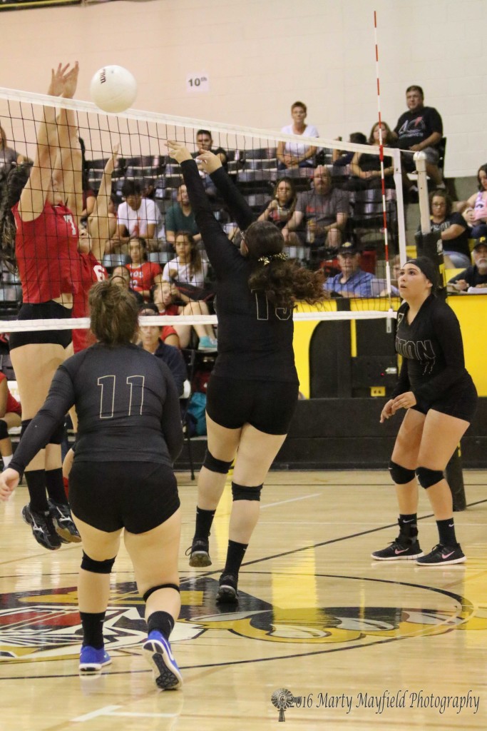 Mariah Saenz puts the ball up while Emi Fukuda goes up for the block in the JV game Saturday afternoon in Tiger Gym