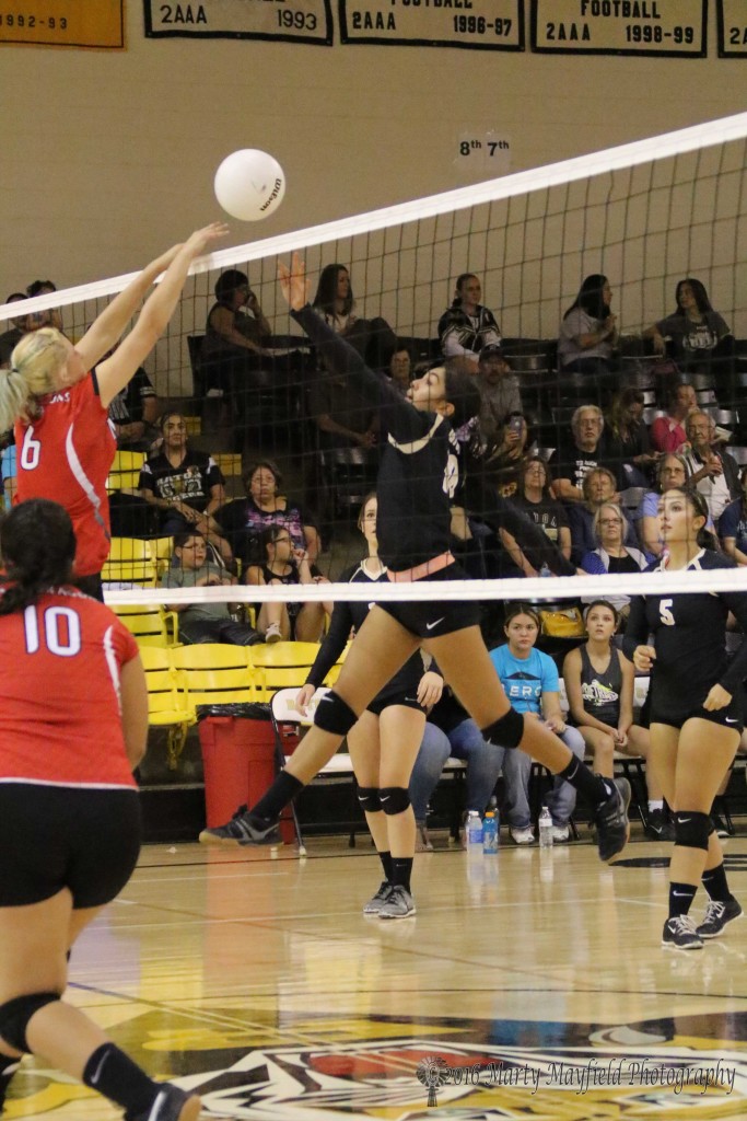 Autumn Archuleta pushes the ball over the net as Talia Flaherty goes up for the block during game one at Tiger Gym.