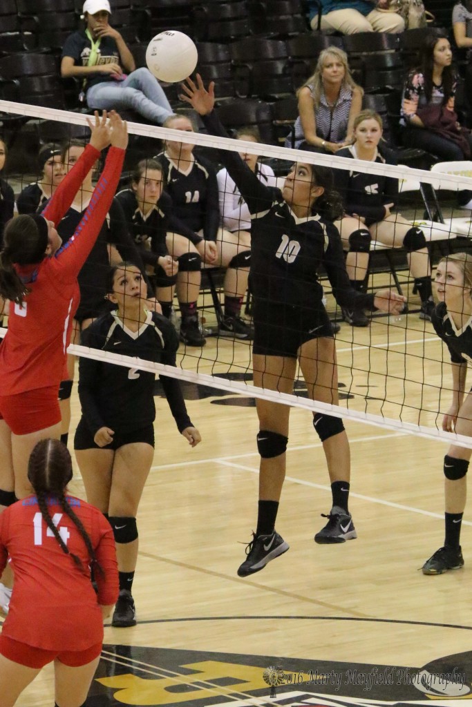Autumn Archuleta makes the hit over the net as Harbor Kerby sets up for the block 