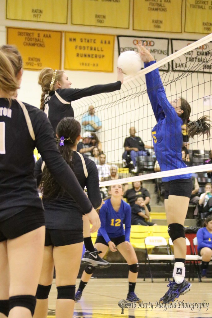 Carly Gonzales gets a tip on the ball as Alina Pilmore pushes the ball over the net Thursday evening in Tiger Gym 