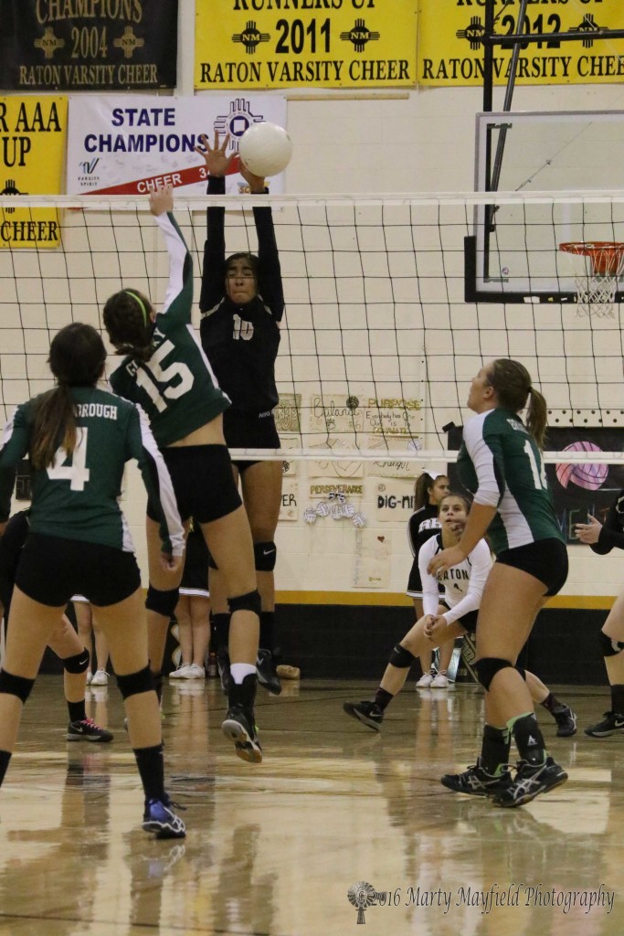 Autumn Archuleta goes up for the block and gets a hand on the ball after Michaela Glinsky (15) sends it over the net