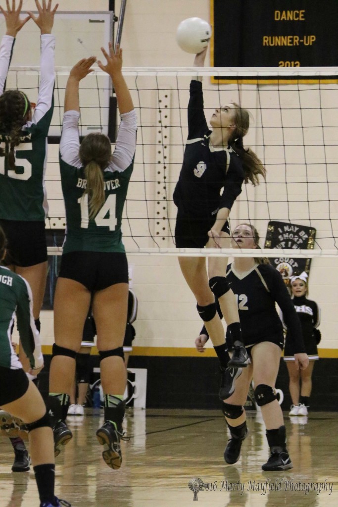 Alina Pilmore makes the hit as Courtney Brookover (14) and Michaela Glinsky (15) go up for the block. 