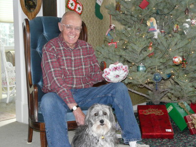 Mickey Baker, with his dog Sam, holds a dish his mother, Jenny Baker, used to serve cranberry salad for Christmas and other holidays. Baker grew up in the coal camp of Sugarite.