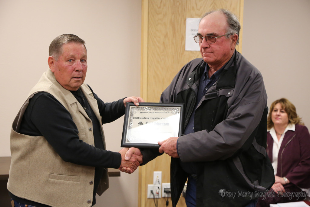 Carl Swanson receives a certificate of appreciation for the painting he has done that hangs in the city commission chambers.