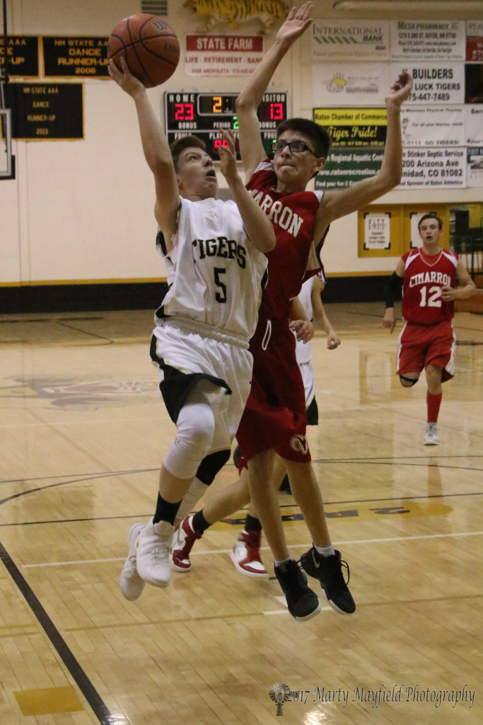 Silver Hunnicutt takes the ball to the basket as David Gonzales works for the block during the JV game Thursday evening in Tiger Gym.