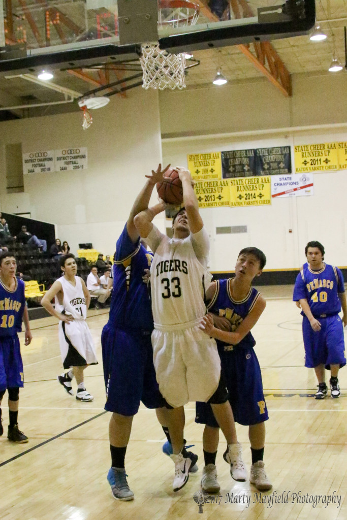 Christian Snyder takes the shot as Danny Esquivel goes for the block while Jude Encinias looks on from behind. 