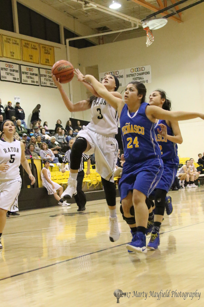 Estrella Vargas(3) drives the lane as Megan Romero(24) gets a hand in the way during the varsity game Saturday evening