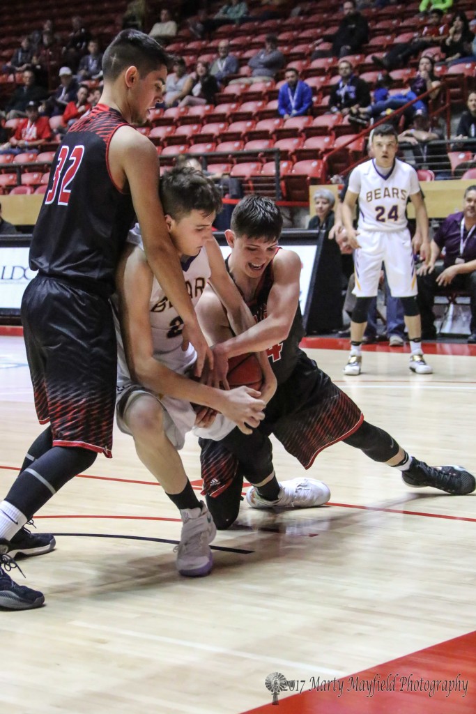 Kolton Riggs, Isaiah Garcia and Zac Caldwell struggle for the ball before the refs finally call a tie ball as both boys head for the floor Saturday morning in Wise Pies Arena