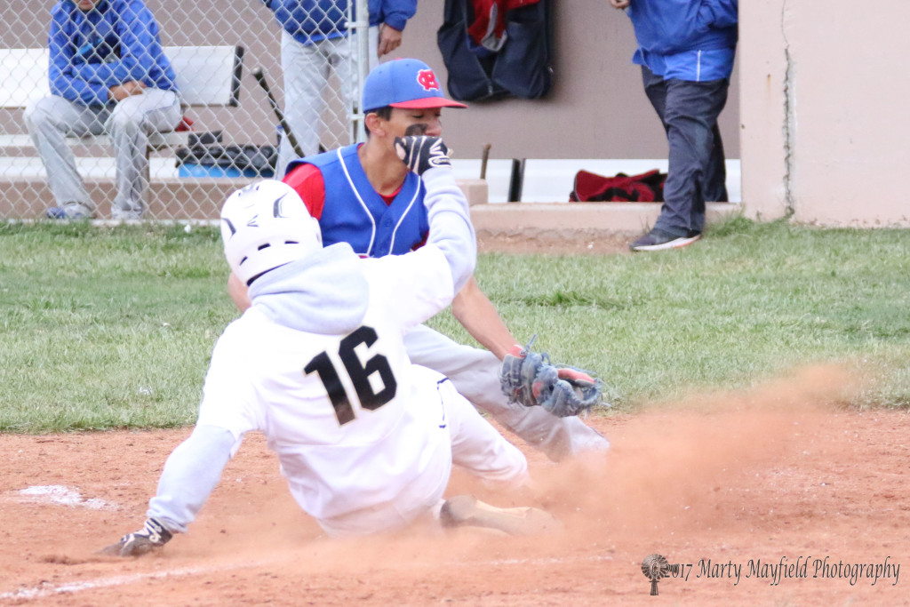 In a cloud of dust Richie Gonzales makes the slide safe into home plate Saturday afternoon against McCurdy