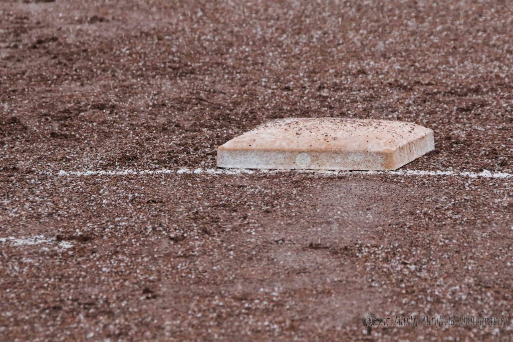 First base sits alone in the rain and sleet Tuesday afternoon during a brief stoppage in play.