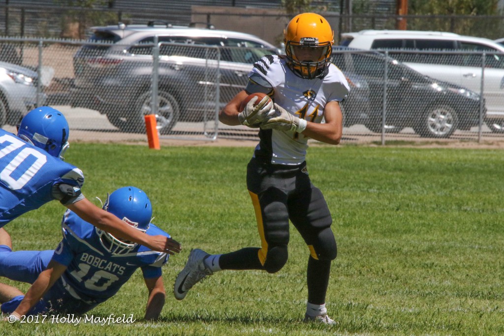 Ismael Tafoya goes wide to avoid tacklers during the game in Espanola against the McCurdy Bobcats Saturday afternoon. 