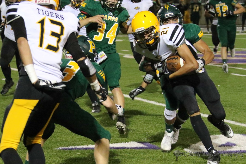 Gabe Martinez(21) is greeted by a host of Pampa Harvesters as he tries to move up field in Dalhart.