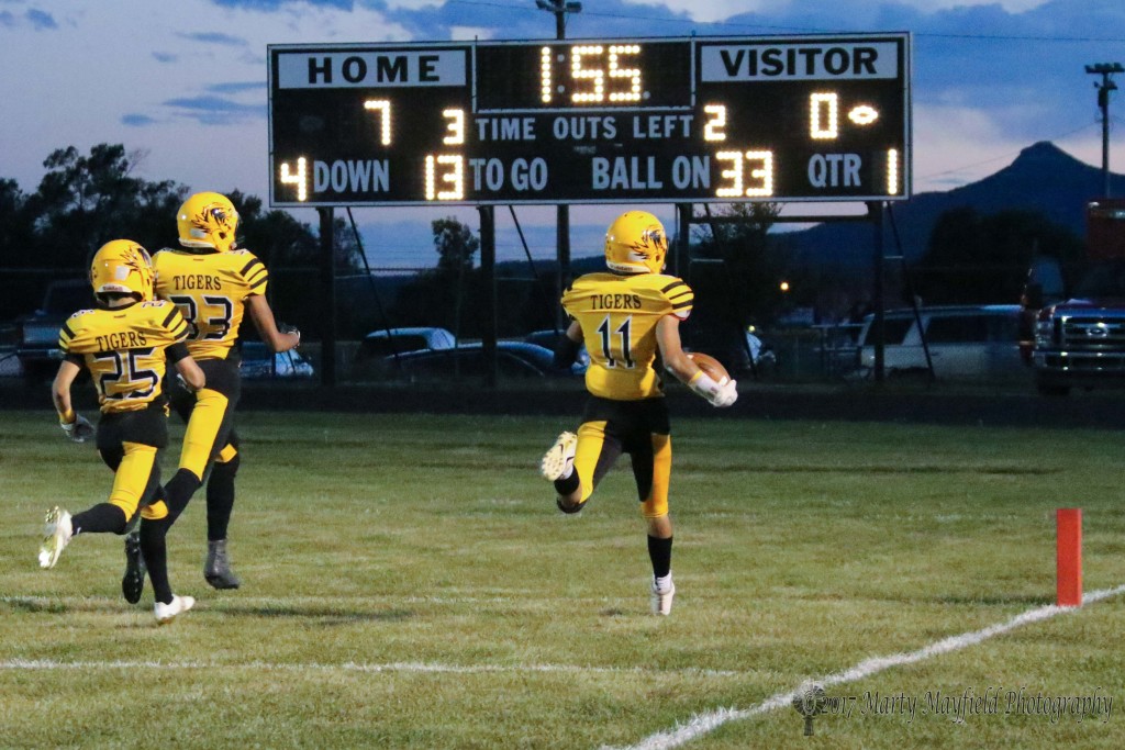 Followed up by Dante Romero(25) and Darien Lewis (33) Ismael Tafoya scampers across the goal line for the second of several touchdowns made by Raton Friday evening. 