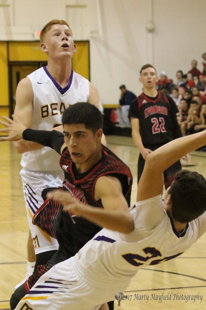 2 of 2 Bryan Romero goes in for the shot as Jeremy Archuleta sets to take the foul in what was called the State Championship rematch between Maxwell and Springer during the 2017 Cowbell Tourney. 