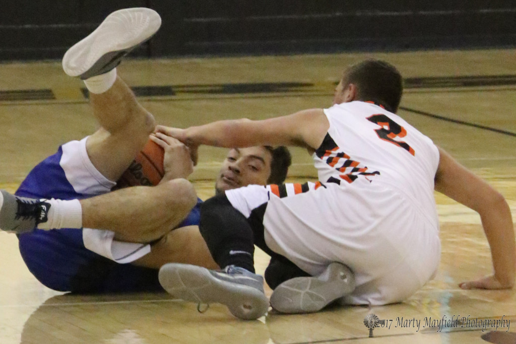 Its a scramble for the ball as Isiah Valdez and Geo Swagerty take tot he floor to gain possession of the ball during the 2017 Cowbell Tourney Saturday morning in Tiger Gym. 
