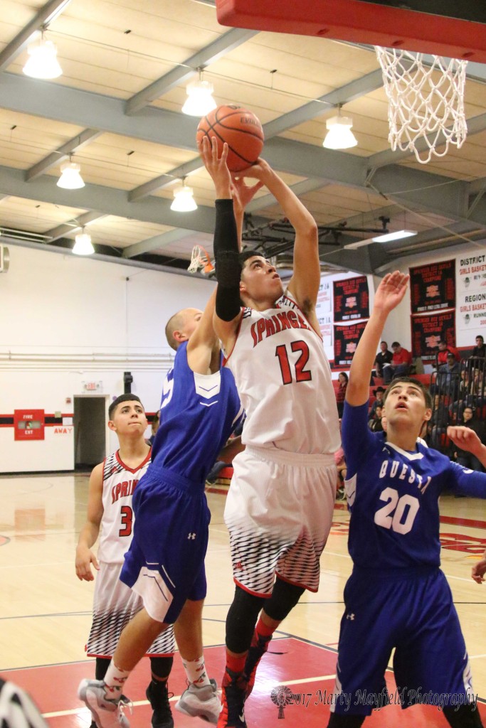 Brian Romero goes up for the shot followed by a couple of Questa Wildcats at the 2107 Cowbell in Springer Tuesday night. 