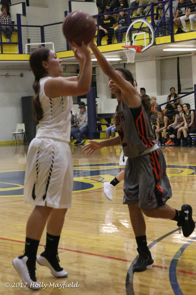 Andie Ortega takes the shot as Courtney Metzgen goes for the block during the 2017 TSJC Tourney in Scott Gym Friday night. 