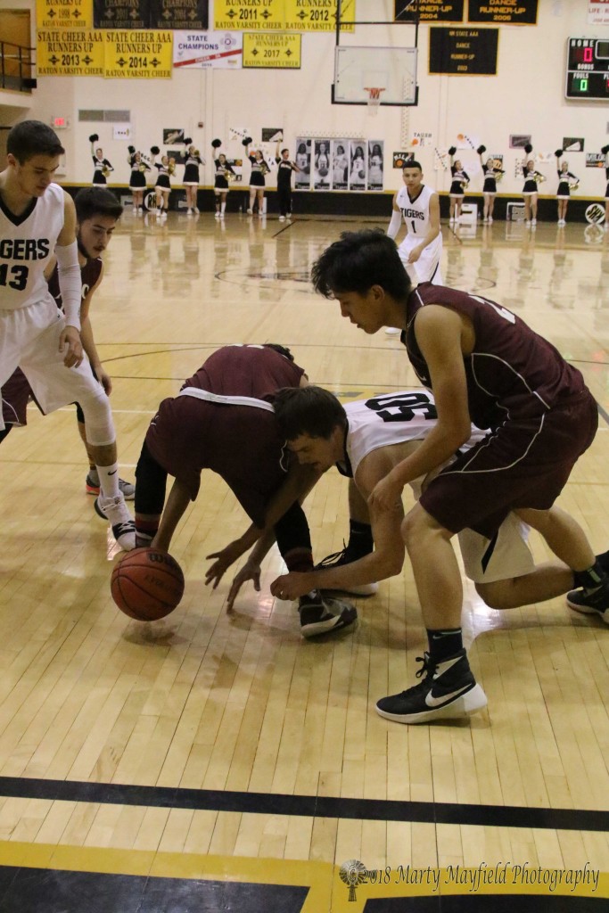 To the floor to try and grab the loose ball. David Prada and Nathaniel Tarbox scramble for the ball early in the district game between Raton and ATC.