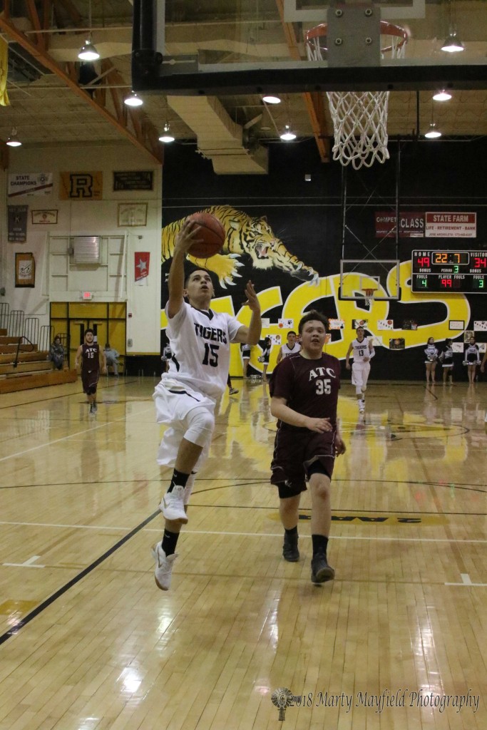 Isaiah Samora drives the lane ahead of Chris Brewer during the district game in Raton Thursday evening.