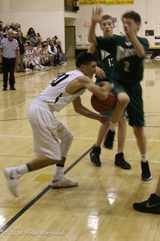 Ismael Tafoya almost looses the ball as it hits Cyrus Curtis in the leg as Tafoya goes into the lane Saturday evening. 