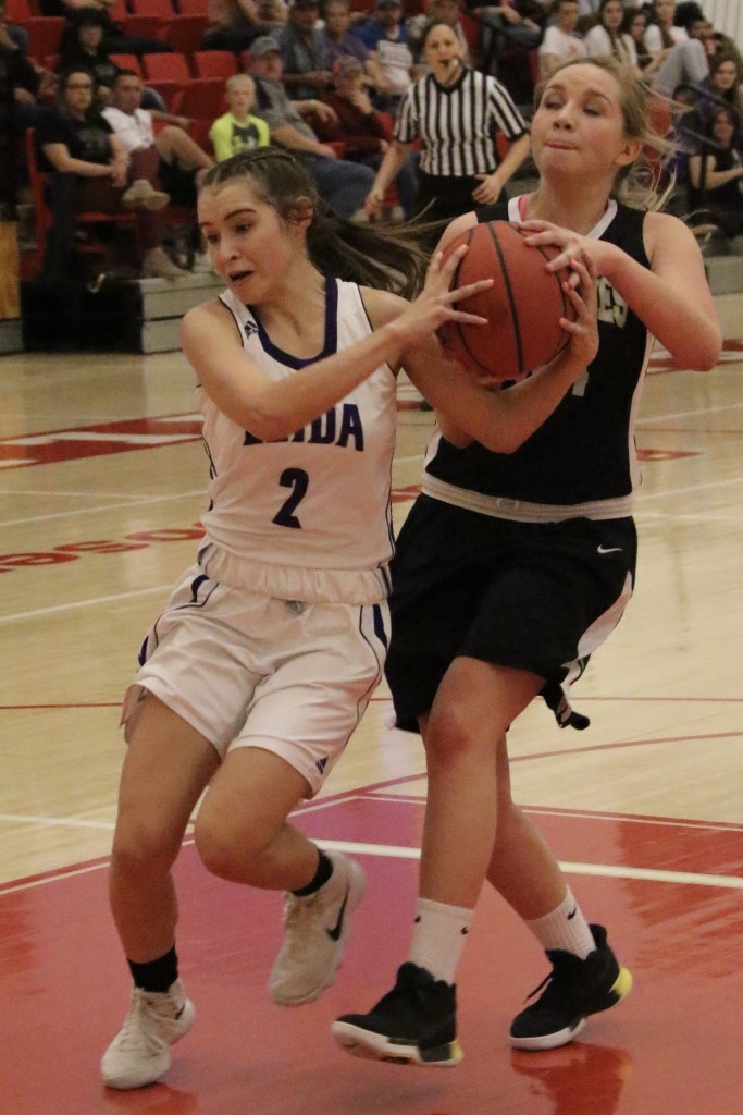 Alyssa Bargas and Natashia McDonald tangle over the ball as McDonald headed for the basket.