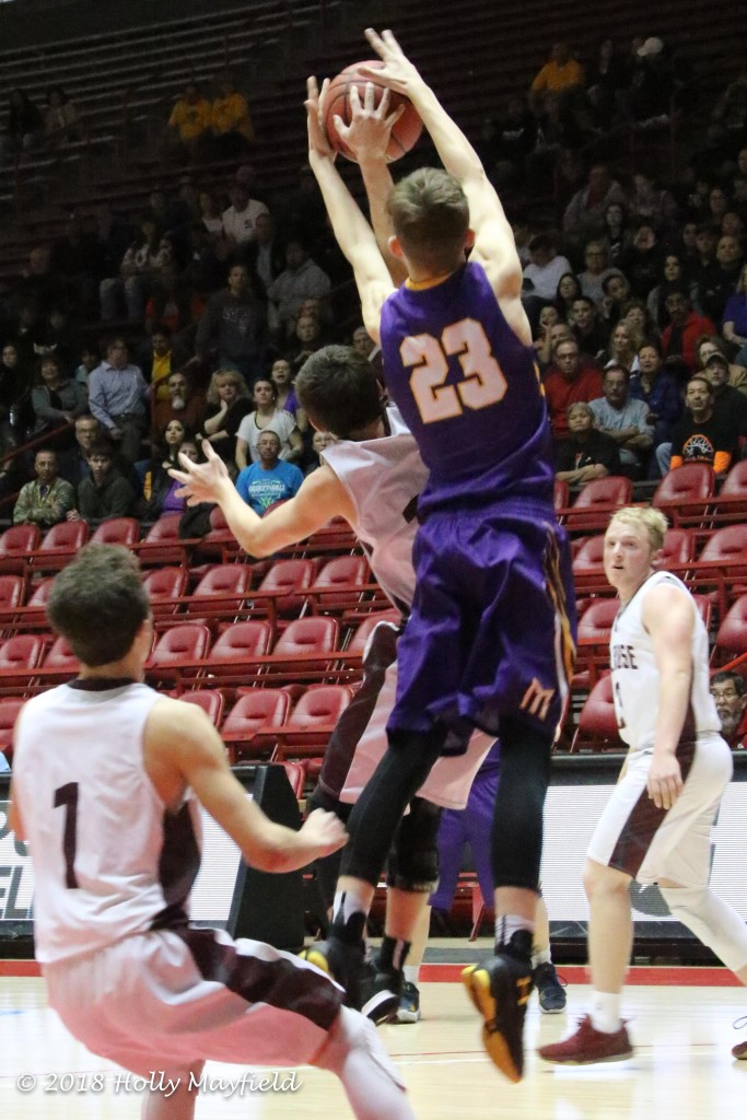 Sterling Sena tries to get a hand on the ball as Kolton Rigs makes the grab on the rebound, a scene that played out often in the struggle for rebounds during the state title game Saturday morning. 