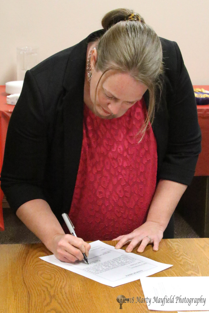 Lori Chatterly signs on the dotted line accepting the Oath of Office for her new position as Raton City Commissioner Monday evening at City Hall.