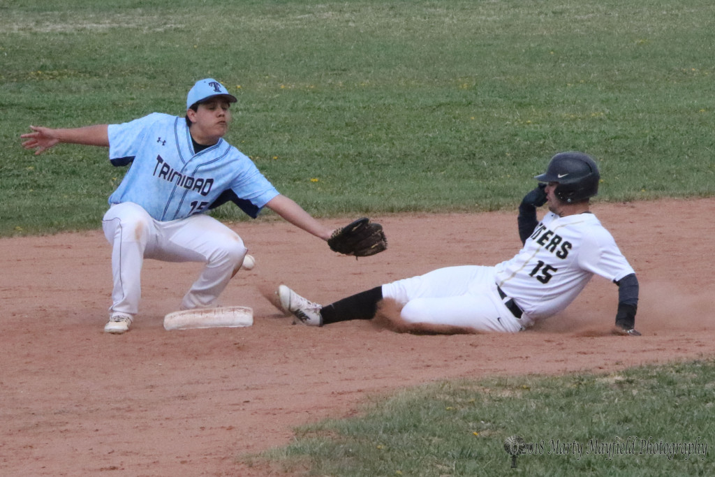 Cole Medina makes it to second as the ball goes on past Trinidad second baseman Jacob Valdez Tuesday afternoon.