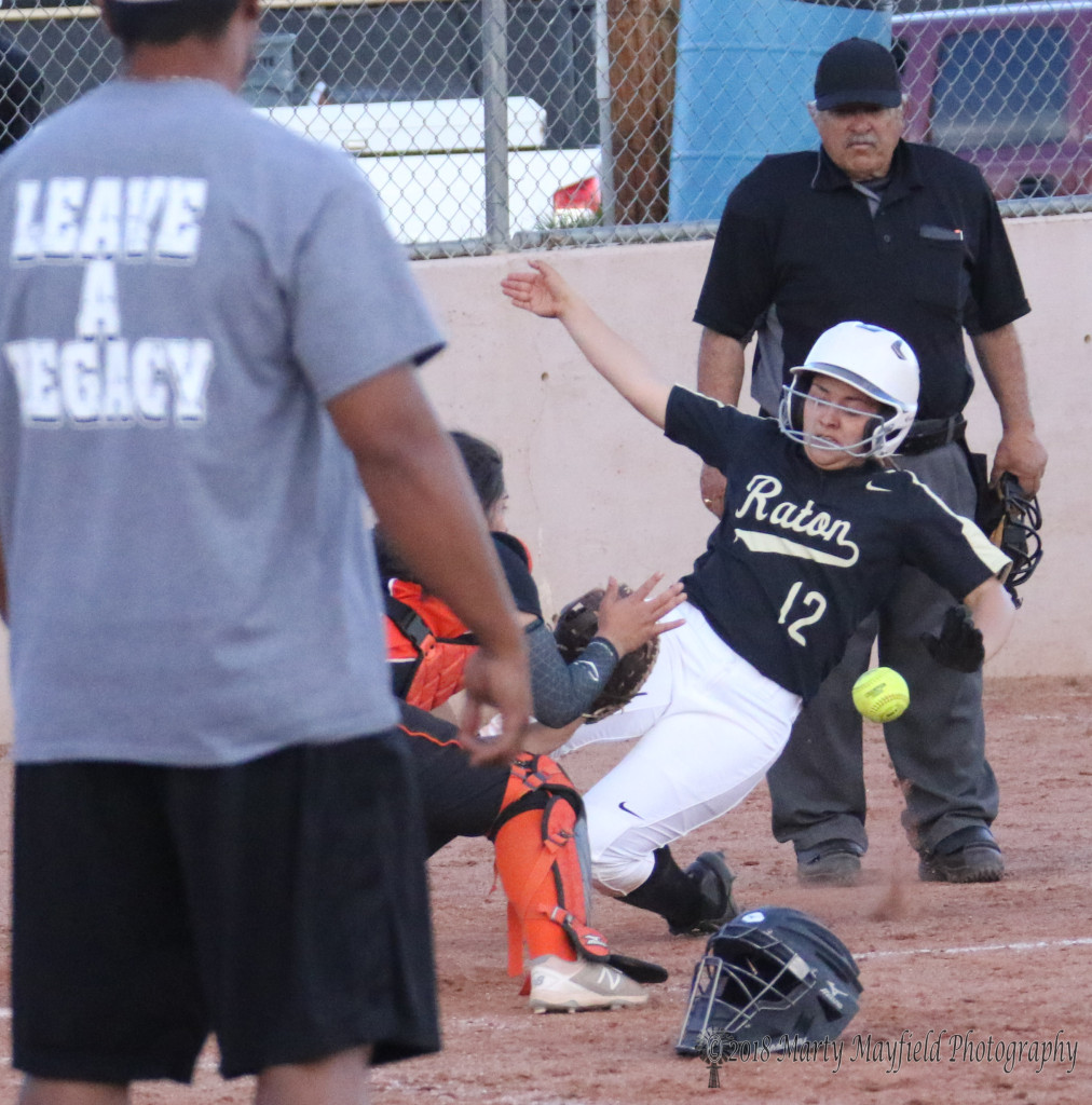 Another safe slide into home plate just ahead of the ball as Andie Ortega just beats the tag by Taos catcher Ariana Aguilar Tuesday at Jim Wade Field 