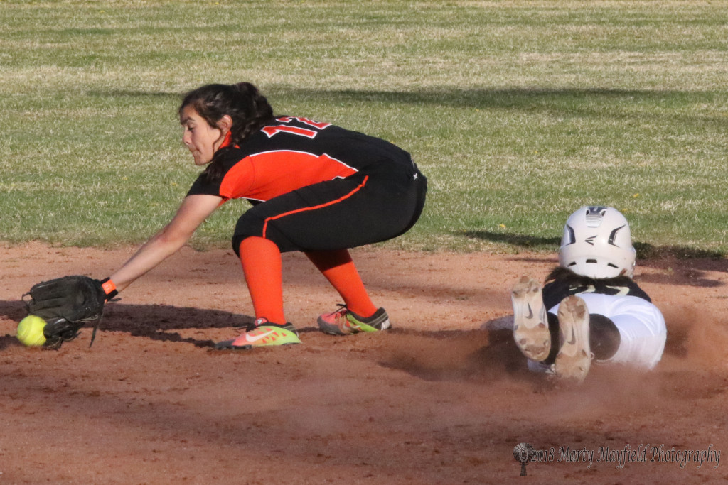 Camryn Mileta slides into second as Ashlynn Silva works for the low throw from the catcher Tuesday afternoon in game two of the double header against Taos. 